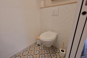 a bathroom with a toilet and a tile floor at Au petit jardin d'Aizenay in Aizenay +9 photos