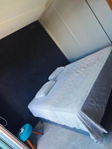a small bedroom with a bed in a room at suite ampla em sobrado com ar e garagem in Cascavel