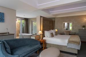 a hotel room with a bed and a chair and a couch at Wild Mushroom Country House in Stellenbosch