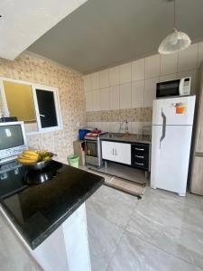 a kitchen with a white refrigerator and a counter top at Suíte por do sol 3 casa compartilhada in Xangri-lá +9 photos