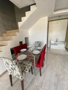 a dining room with a table and red chairs at Suíte por do sol 3 casa compartilhada in Xangri-lá