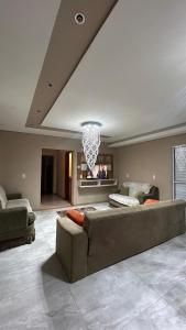 a large living room with a couch and a chandelier at Suíte por do sol 3 casa compartilhada in Xangri-lá