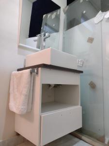 a bathroom with a sink and a mirror at Suíte por do sol 3 casa compartilhada in Xangri-lá
