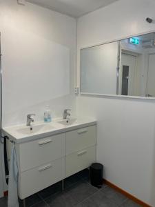 a bathroom with two sinks and a large mirror at Laplanders room 3 in Kiruna +3 photos