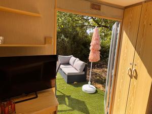 a living room with a couch and a television and a patio at Le joli centre energetique in Châteaumeillant
