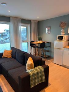 a living room with a couch and a kitchen at Reine Sea Apartment in Moskenes