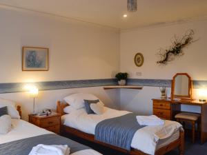 a hotel room with two beds and a mirror at West Tannacrieff in Stewarton +9 photos