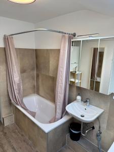 ein Badezimmer mit Badewanne und Waschbecken in der Unterkunft Apartment Oberdeck für 4 Personen, Wifi, Parkplätze uvm in Brokstedt