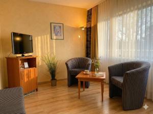 a living room with chairs and a tv and a table at Hotel Hebelhof in Bad Bellingen +15 photos