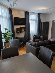 a living room with a couch and a table and chairs at A Fleur de Couette in Auvelais