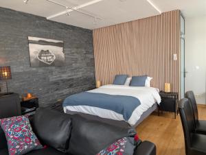 a bedroom with a bed and a couch at A Fleur de Couette in Auvelais +38 photos
