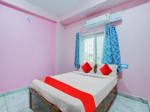 a bedroom with a bed with red pillows and a window at Hotel O Kalinga Inn in Bhubaneshwar