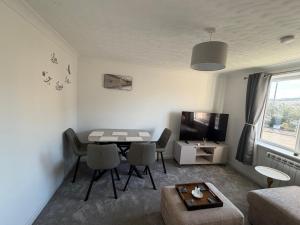 a living room with a table and a tv at Nessy5 Apartment in Inverness