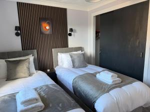 two beds sitting next to each other in a room at Nessy5 Apartment in Inverness