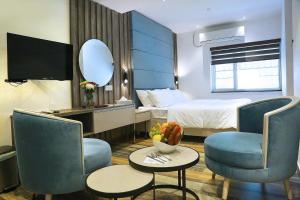 a hotel room with a bed and a table and chairs at Sri Suryas Hotel in Colombo