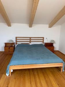 a bedroom with a large bed with a blue blanket at Openspace in legno La Casa sull'Albero in Osimo +7 photos