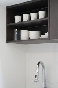 a kitchen shelf with white dishes and a sink at 서초 아트하우스2 in Seoul +18 photos