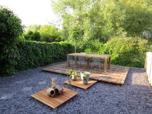 a patio with a table and chairs in a garden at B&B Wiezebed in Wieze