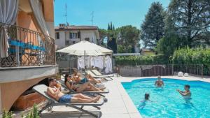 a group of people sitting in a swimming pool at Villa Bugatti Indipendent Villa ,lake view and private pool, DesenzanoLoft Official Partner Homes & Villas by Marriott Bonvoy in Desenzano del Garda
