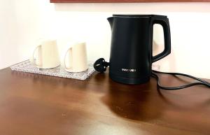 a black coffee pot sitting on top of a table at Lucky Eagle Nest in Tangalle