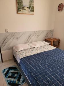 a bed in a bedroom with a blue mattress and a table at Casa Aconchego-Juazeiro do Norte CE Sao Jose in Juazeiro do Norte