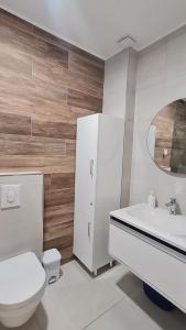 a white bathroom with a toilet and a sink at La Vista Apartment in Petrovac na Moru