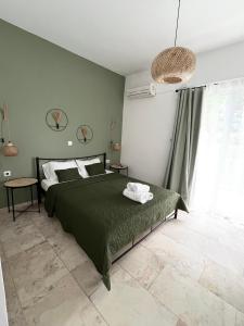 a bedroom with a bed with a green blanket at LaMar in Skala Prinou