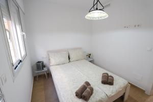 a bedroom with a bed with shoes on it at CostaFlo in Gran Alacant +25 photos