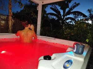 a man in a jacuzzi tub in a backyard at Caravana en la huerta in Tiñosa Alta +7 photos