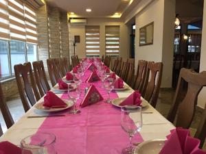 a long table with pink napkins and wine glasses at Hotel Split in Usora +4 photos