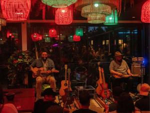 a group of people sitting in a room with guitars at HEJMO Hostel in Hossegor +66 photos