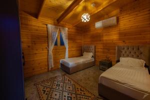 a bedroom with two beds in a wooden room at اكواخ لوسو الريفيه in Ḩayy al Ḩamdānīyah +84 photos