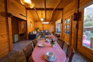 a dining room with a table and a couch at اكواخ لوسو الريفيه in Ḩayy al Ḩamdānīyah