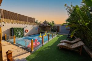a swimming pool with a pink flamingo in the grass at اكواخ لوسو الريفيه in Ḩayy al Ḩamdānīyah
