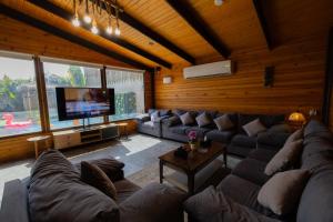 a large living room with couches and a tv at اكواخ لوسو الريفيه in Ḩayy al Ḩamdānīyah