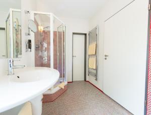 a bathroom with a sink and a shower at Garni-Hotel An der Weide in Berlin