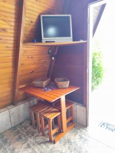 a wooden table with a tv on a wall at Chalés Caraguatatuba in Caraguatatuba