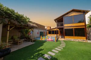 a backyard with a playground and a house at اكواخ لوسو الريفيه in Ḩayy al Ḩamdānīyah