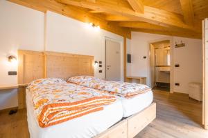 a large bed in a room with wooden ceilings at Garnì dal Mozat in Ledro