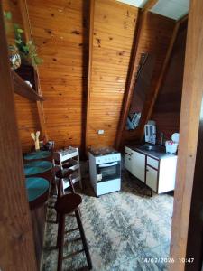 a kitchen with wooden walls and stools in a room at Chalés Caraguatatuba in Caraguatatuba +11 photos