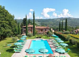 a resort with a swimming pool with umbrellas at Agriturismo La Casina in Caprese Michelangelo
