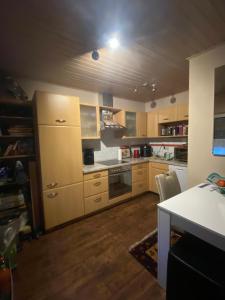 a large kitchen with wooden cabinets and a table at Haus Ferienglück in Zadelsdorf +7 photos