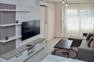 a living room with a flat screen tv on a wall at Flat in Shëngjin Beachfront Getaway in Shëngjin