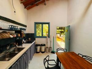 a kitchen with a table and a sink and a table and chairs at Refugio Ilha Grande in Angra dos Reis