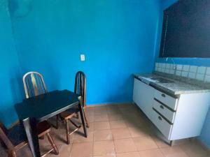 a blue kitchen with a table and a table and chairs at Loft Sousas in Campinas