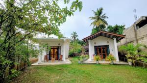 a house with a lawn in front of it at Cozy place in Ahangama