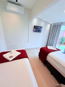 a bedroom with two beds and a window in it at NAVEGA HOSTEL - Rede Navega Hotéis in Navegantes