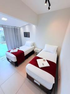 a hotel room with two beds and a window at NAVEGA HOSTEL - Rede Navega Hotéis in Navegantes