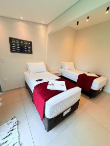 a room with two beds in a room at NAVEGA HOSTEL - Rede Navega Hotéis in Navegantes