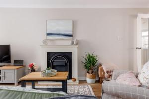 a living room with a couch and a fireplace at Edward Cottage - Old Town Poole Home, Moments from Poole Quay in Poole +31 photos